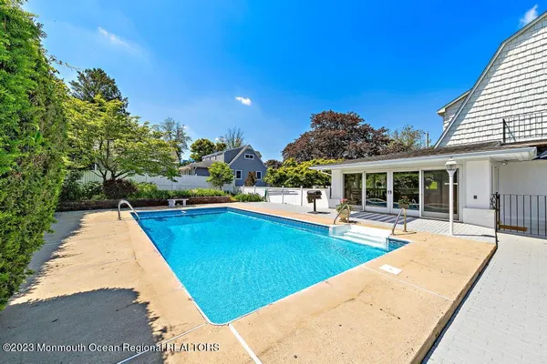 a view of a house with swimming pool and sitting area