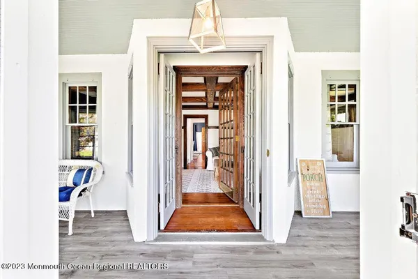 a view of a hallway with wooden floor and a dining room view