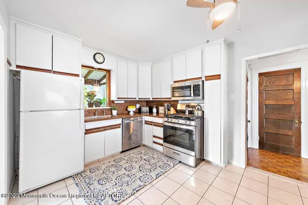 a kitchen with stainless steel appliances granite countertop a refrigerator sink and stove