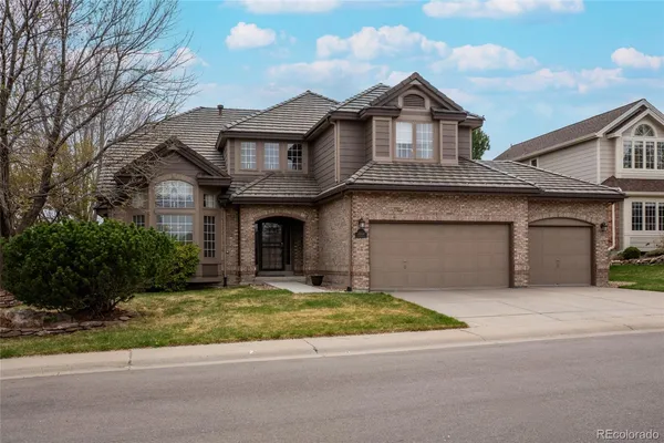 a front view of a house with a garden and garage