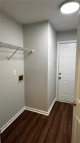 an empty room with wooden floor and cabinet