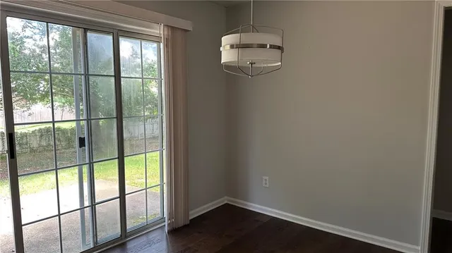 en empty room with wooden floor and windows