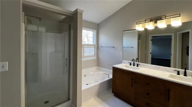 a bathroom with a double vanity sink a large mirror and a shower