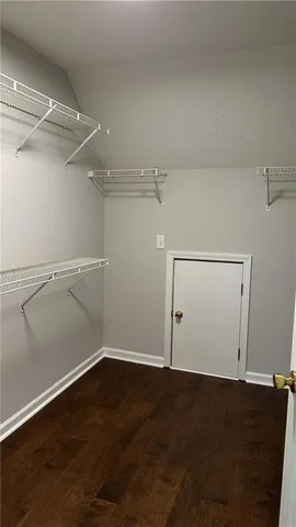 an empty room with wooden floor and empty shelves