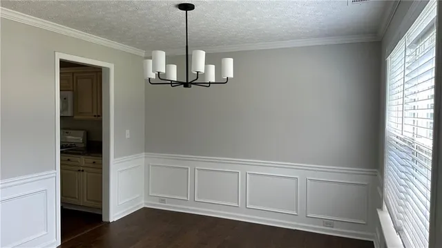 a view of empty room with wooden floor and window