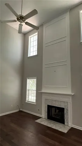 an empty room with wooden floor fireplace and window