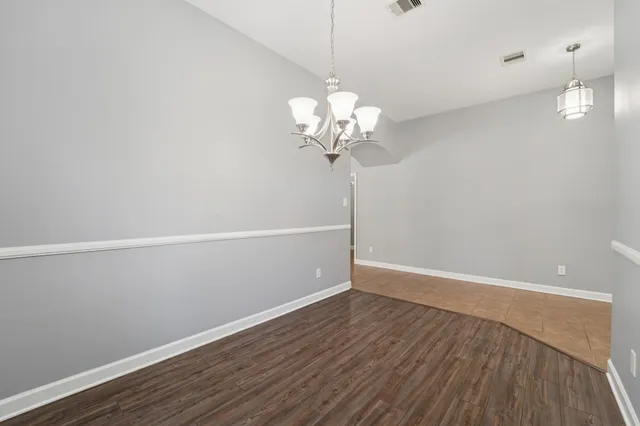 a view of a room with wooden floor and chandelier