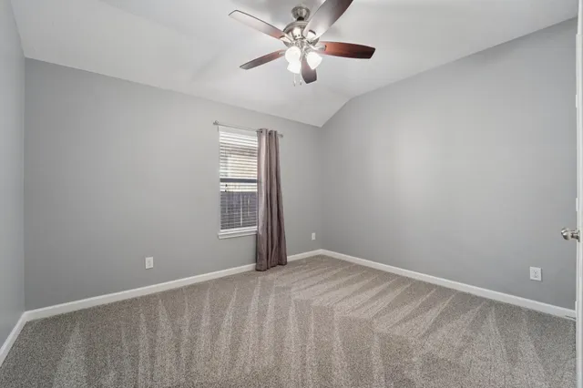 a view of a room with a ceiling fan and a window