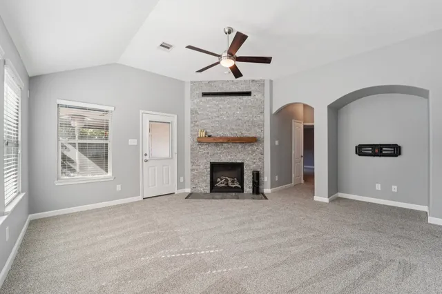 a view of an empty room with window and fire place