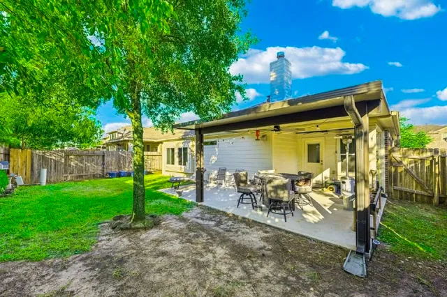 a view of a patio with table and chairs under an umbrella
