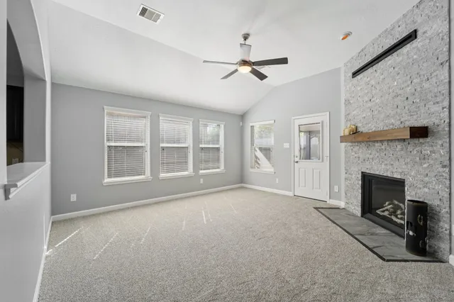 a big room with windows and fireplace