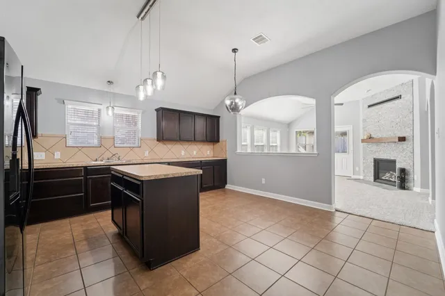 a kitchen with granite countertop a stove a sink and a refrigerator
