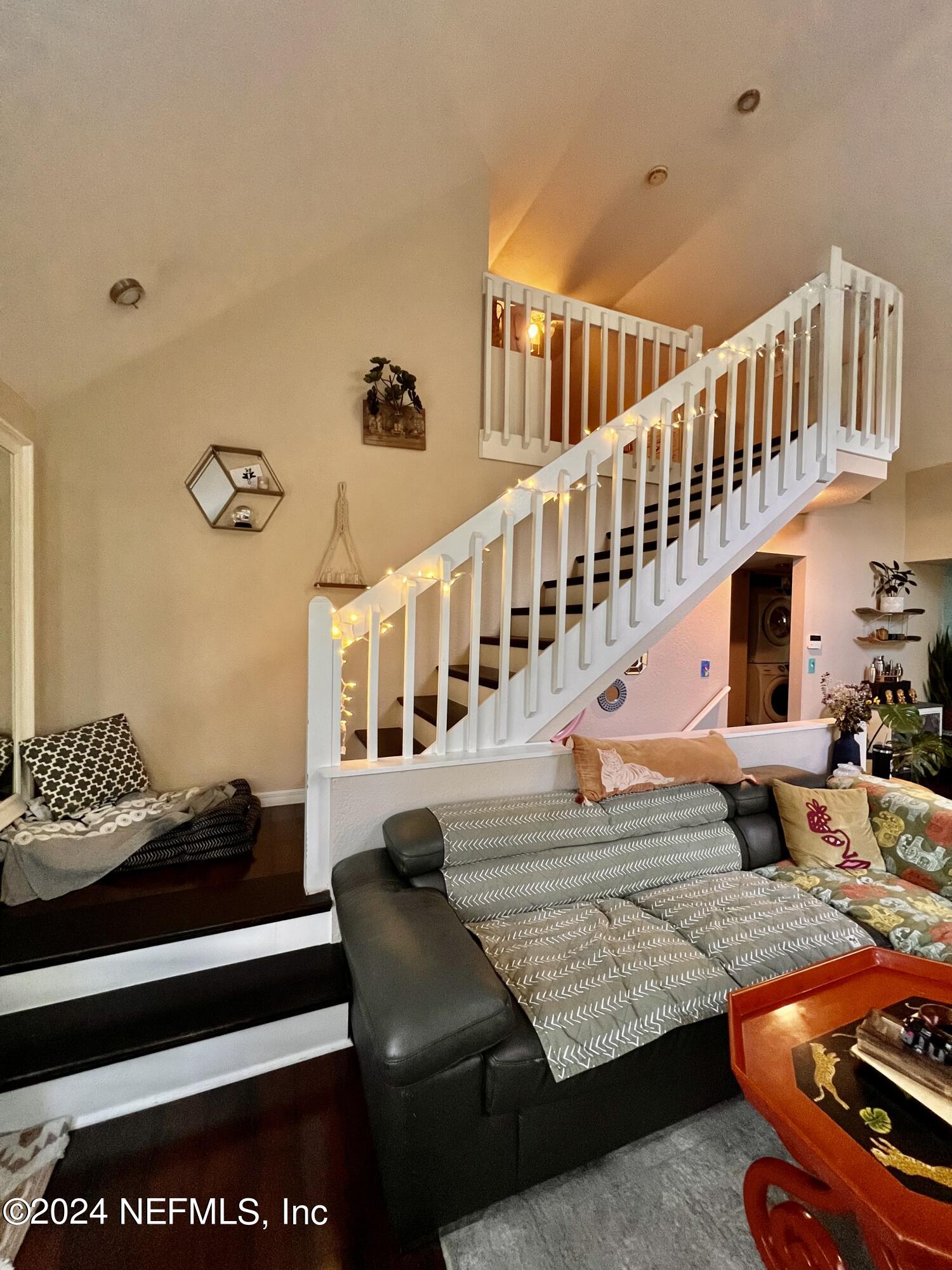 a living room with furniture stairs and a rug