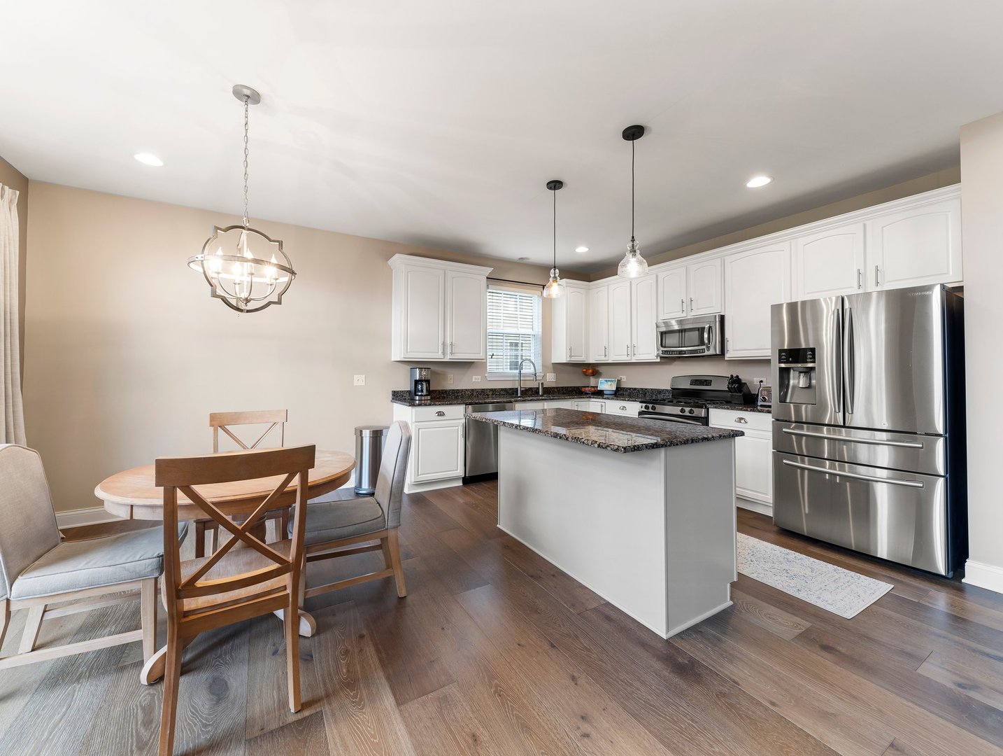 26305 Mapleview Drive Plainfield, IL 60585 - Photo 9 of 40 a kitchen with granite countertop stainless steel appliances a dining table chairs stove and wooden floor