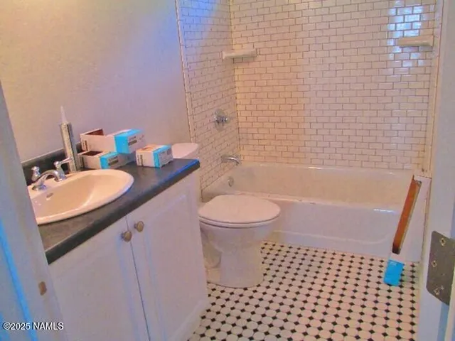 a bathroom with a granite countertop toilet a sink and a shower