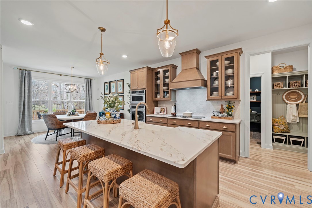 Lot 33 Tuckmar Ridge Drive Moseley, VA 23120 - Photo 3 of 21 a large kitchen with granite countertop a stove a sink a dining table and chairs with wooden floor