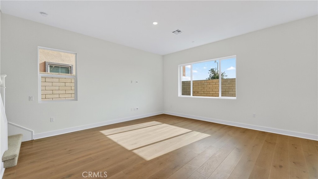 224 Lily Loop Irvine, CA 92618 - Photo 12 of 39 an empty room with wooden floor and windows