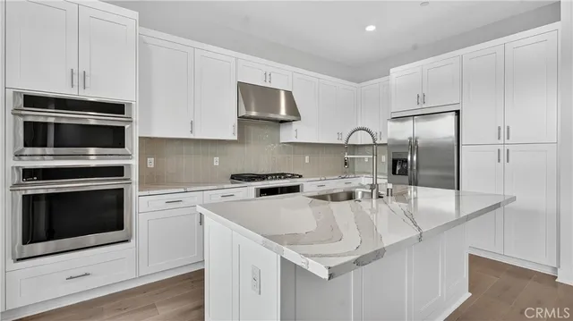 a kitchen with stainless steel appliances granite countertop a sink stove and refrigerator