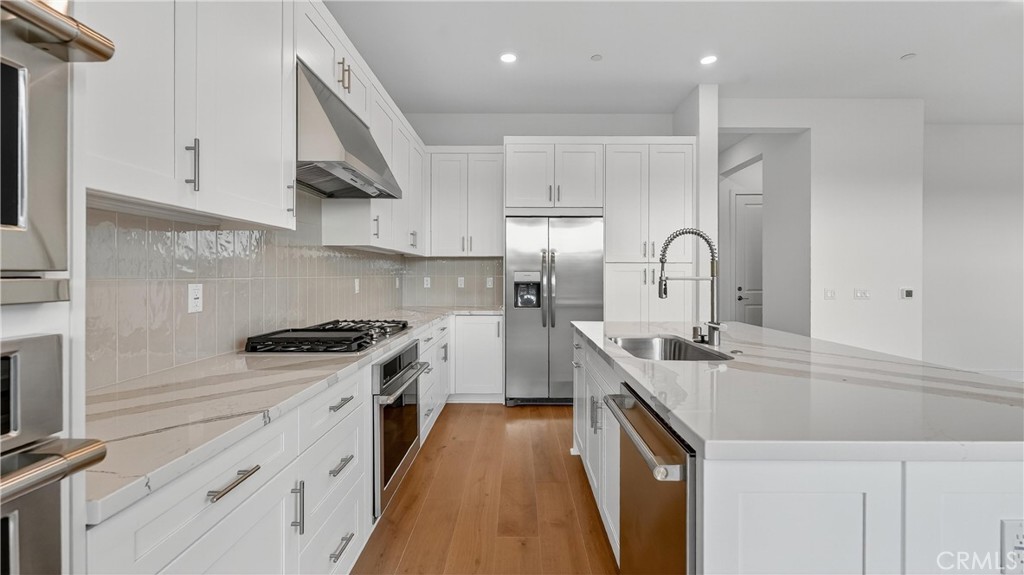 224 Lily Loop Irvine, CA 92618 - Photo 16 of 39 a kitchen with stainless steel appliances granite countertop a sink stove and refrigerator
