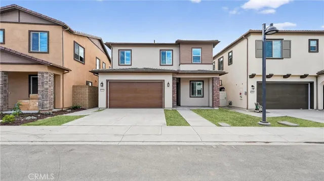 a front view of a house with a yard and a garage