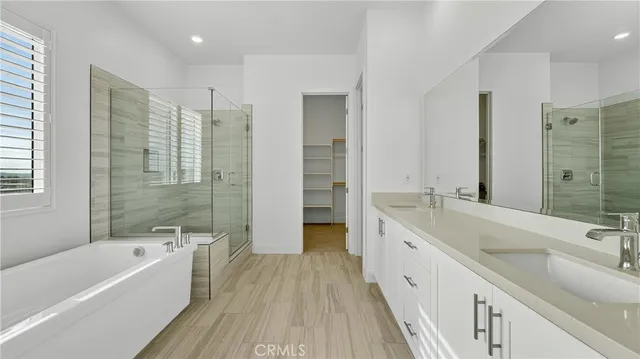 a bathroom with a granite countertop tub a sink and a large mirror
