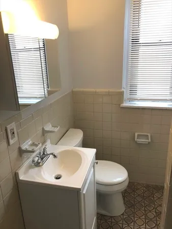 a bathroom with a toilet sink and mirror