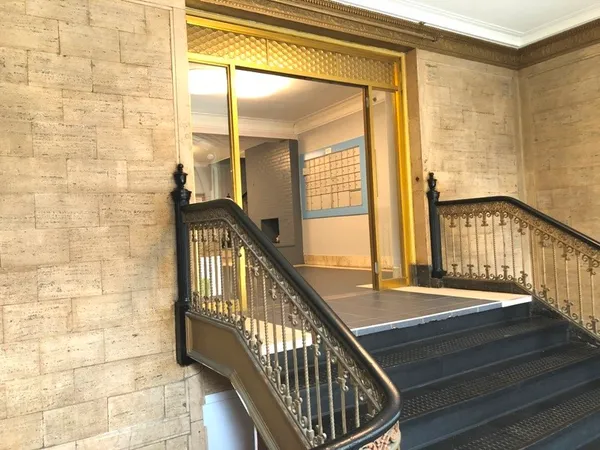a view of staircase with railing and a chandelier