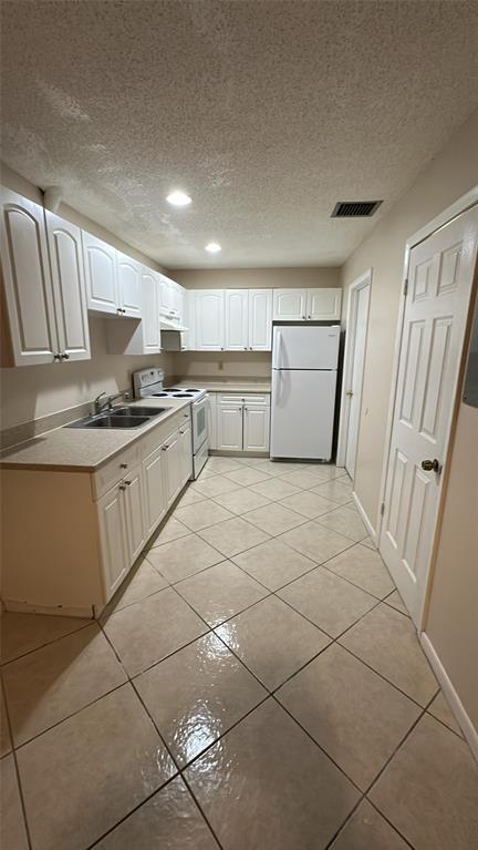 2004 South 10th Street, Unit A Fort Pierce, FL 34950 - Photo 4 of 8 a kitchen with a sink a stove top oven and cabinetry