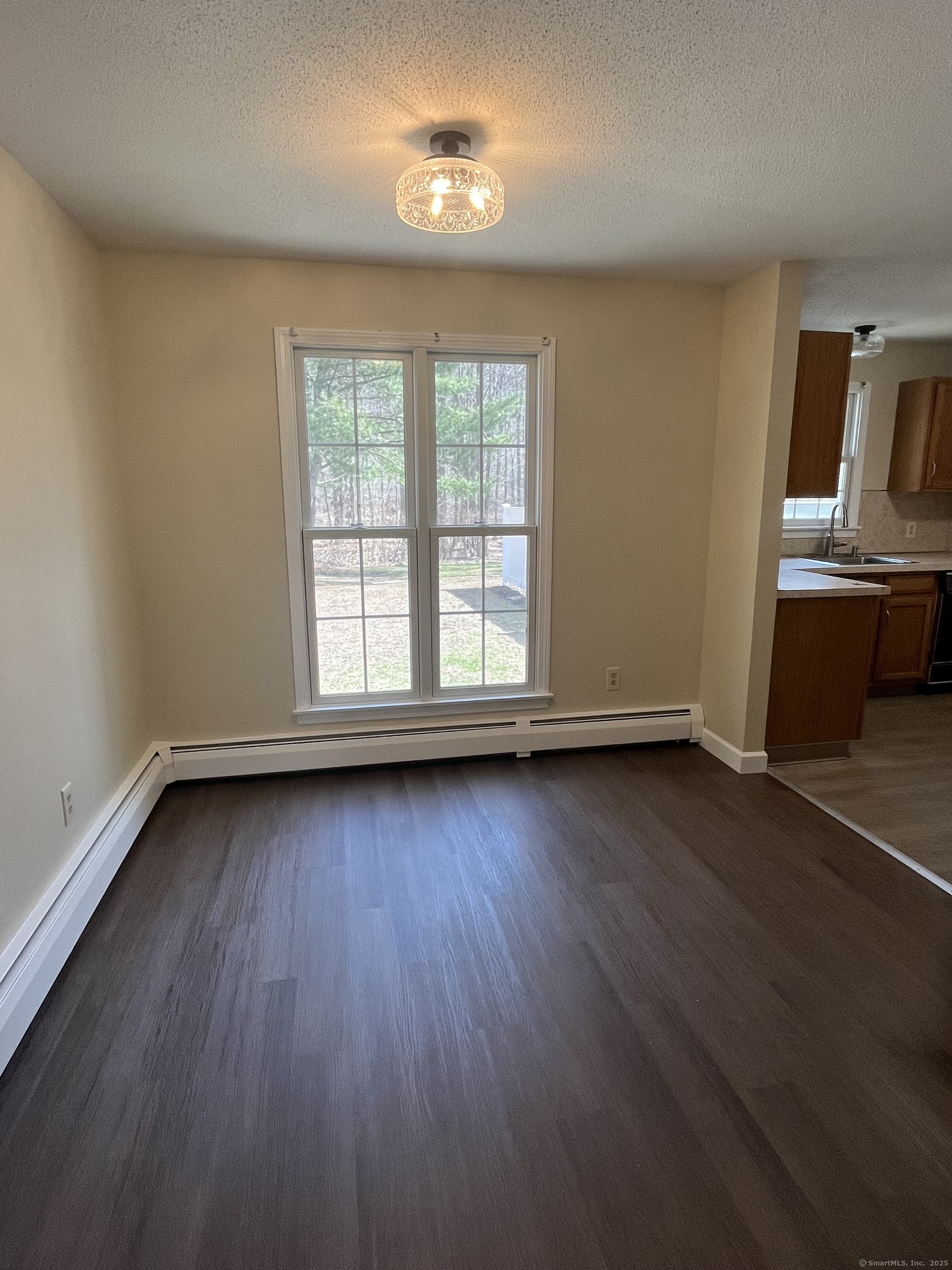 61 Arch Street, Unit 1 Burlington, CT 06013 - Photo 11 of 22 an empty room with wooden floor and windows