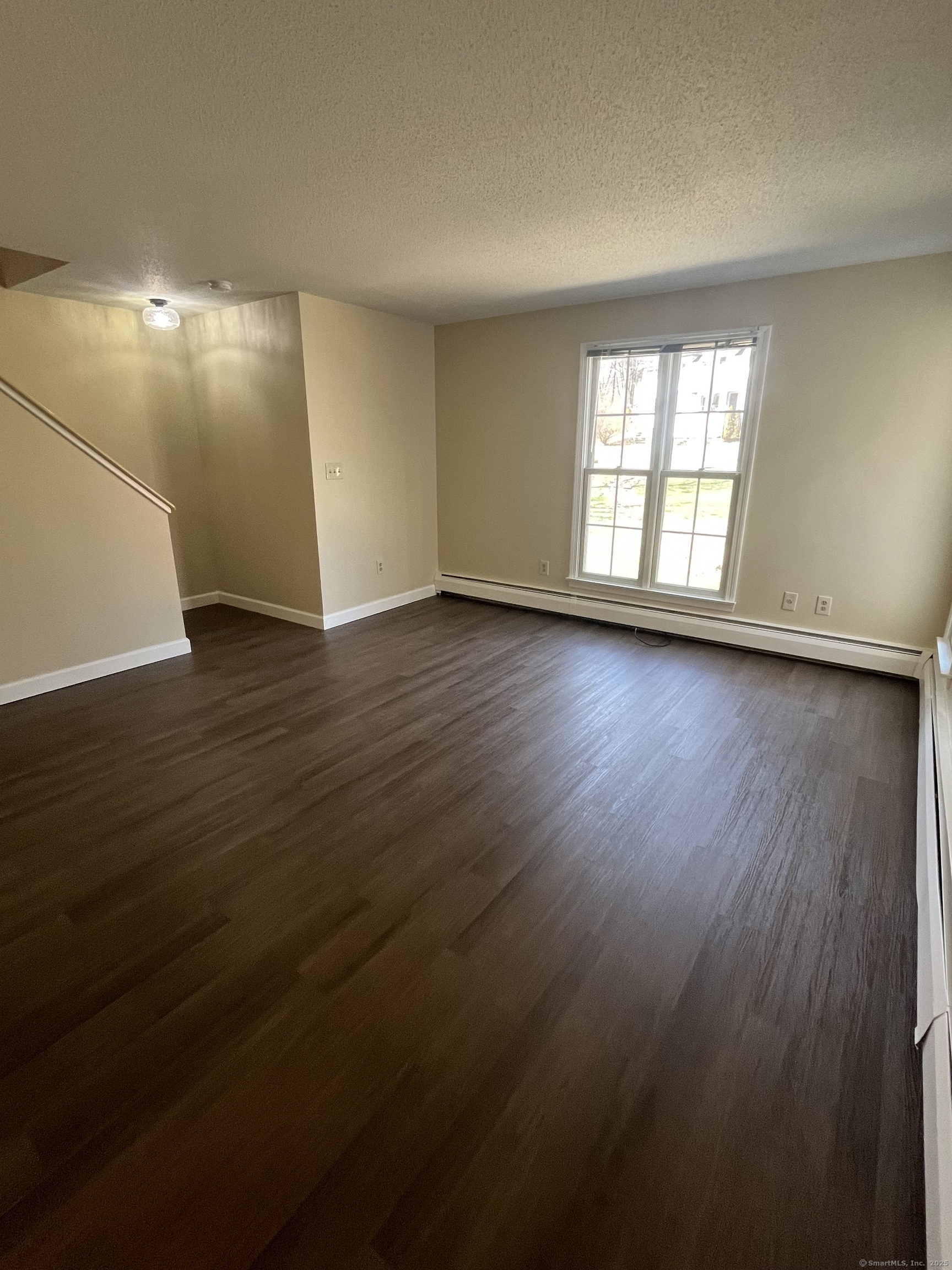 61 Arch Street, Unit 1 Burlington, CT 06013 - Photo 12 of 22 an empty room with wooden floor and windows