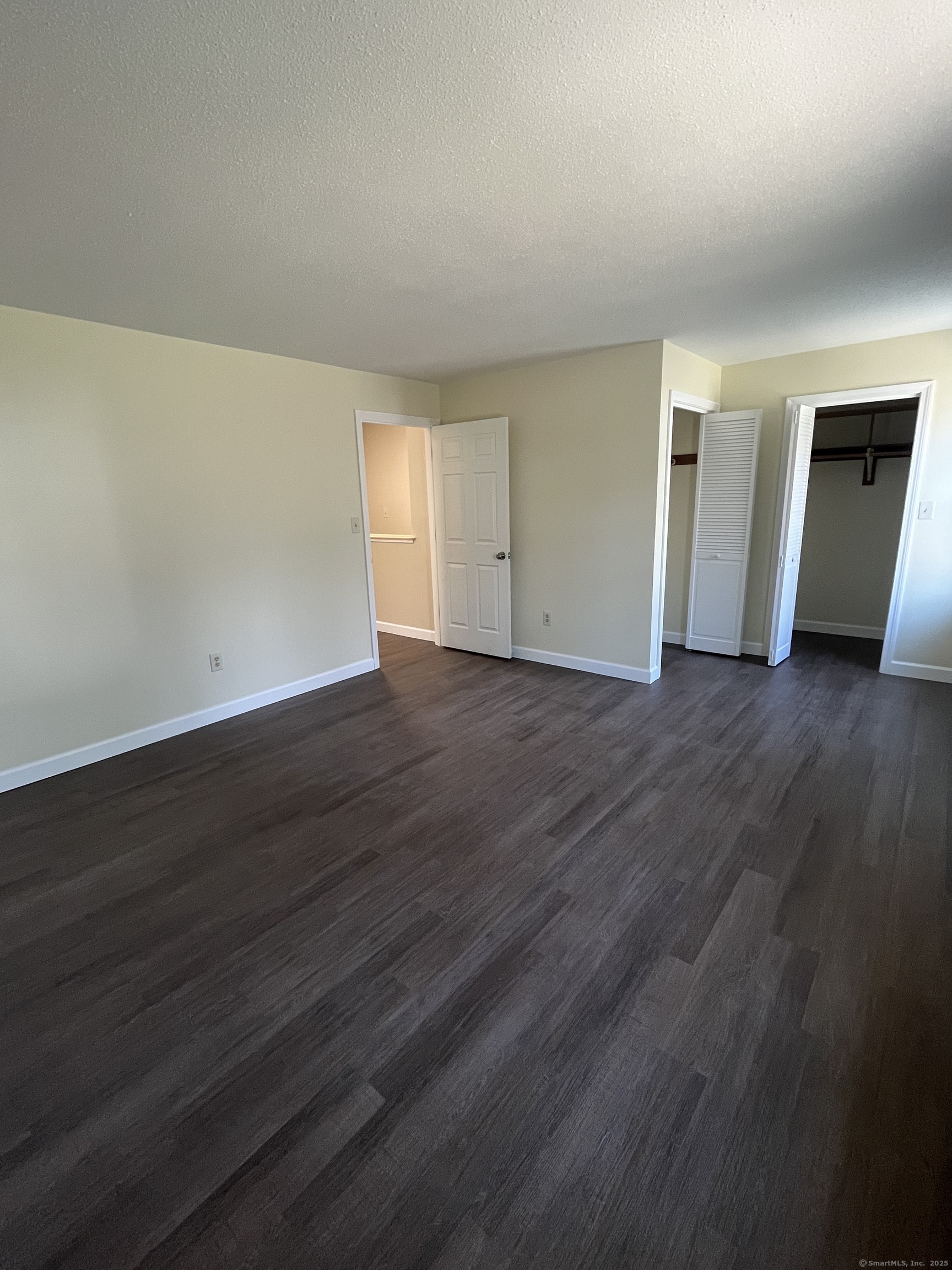 61 Arch Street, Unit 1 Burlington, CT 06013 - Photo 17 of 22 a view of an empty room with wooden floor and closet