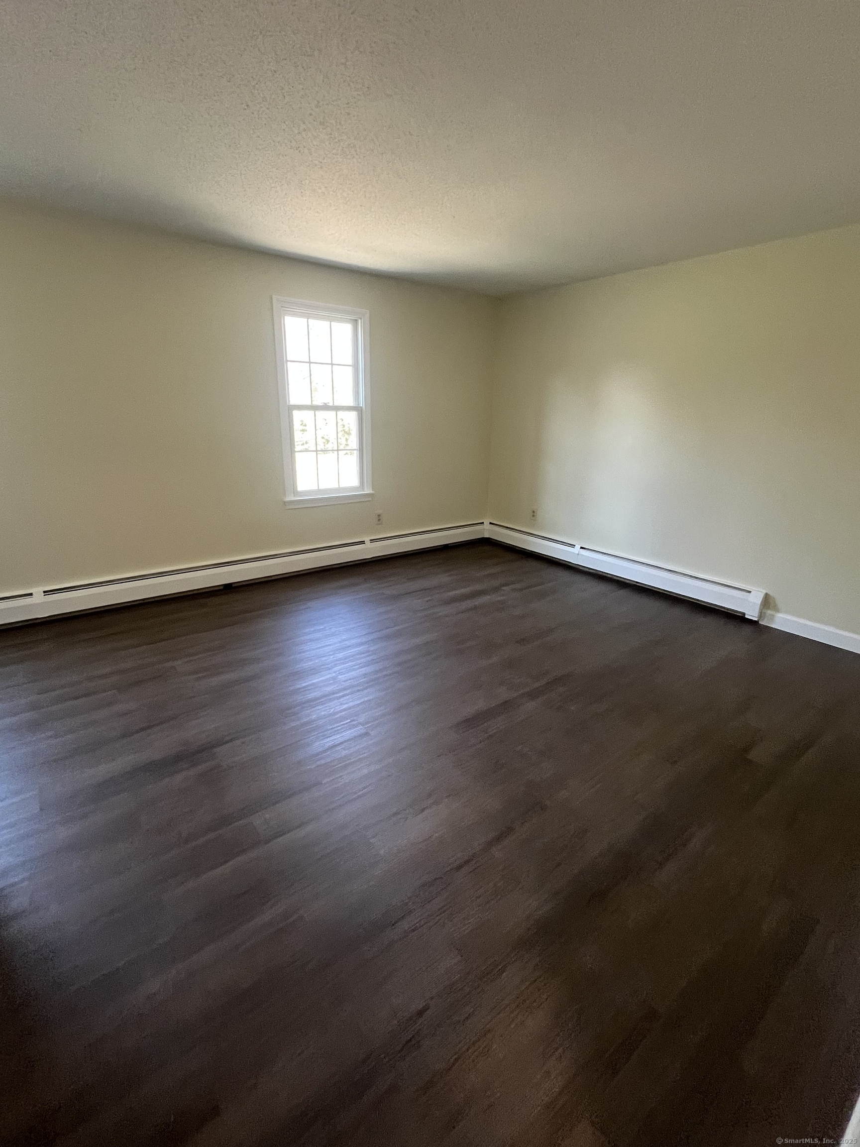 61 Arch Street, Unit 1 Burlington, CT 06013 - Photo 18 of 22 an empty room with wooden floor and windows