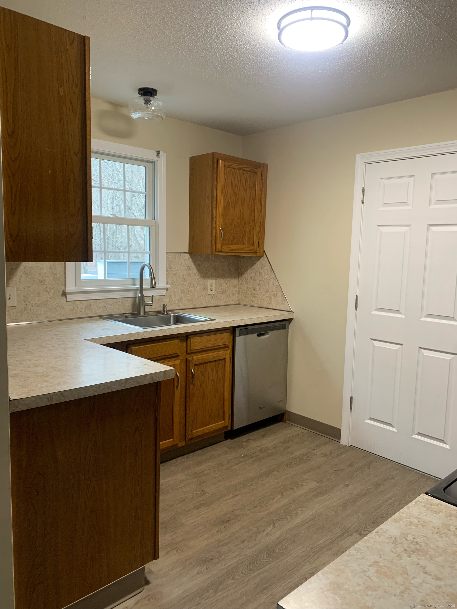 61 Arch Street, Unit 1 Burlington, CT 06013 - Photo 10 of 22 a kitchen with a sink cabinets and window