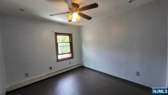 an empty room with a window and a fan