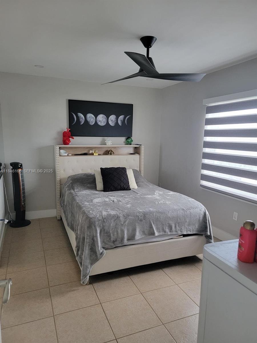 30730 Southwest 156th Avenue Homestead, FL 33033 - Photo 13 of 24 a bedroom with a bed and a chandelier