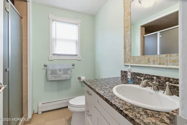 a bathroom with a granite countertop sink a toilet and a mirror