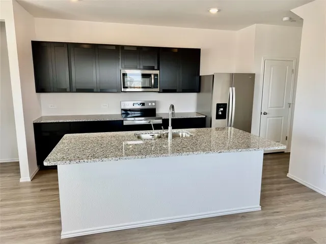 a view of kitchen island wooden cabinets and stainless steel appliances