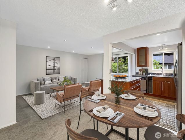 a living room with furniture and a dining table with garden view