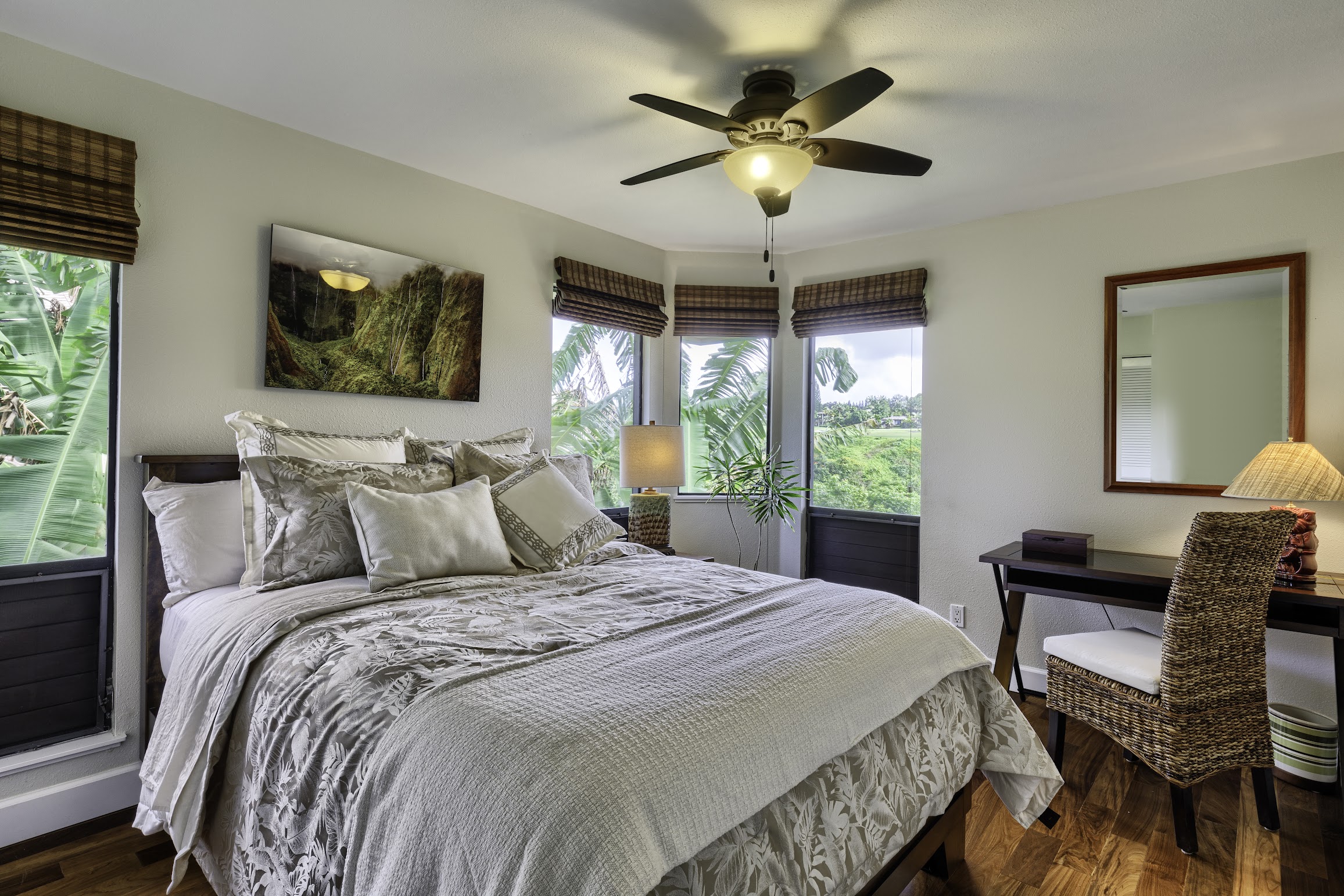 5451 Ka Haku Road, Unit 8 Princeville, HI 96722 - Photo 7 of 14 a bedroom with a large bed and a chandelier