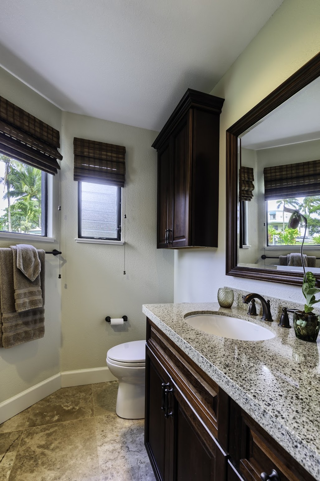 5451 Ka Haku Road, Unit 8 Princeville, HI 96722 - Photo 10 of 14 a bathroom with a granite countertop sink a toilet and mirror
