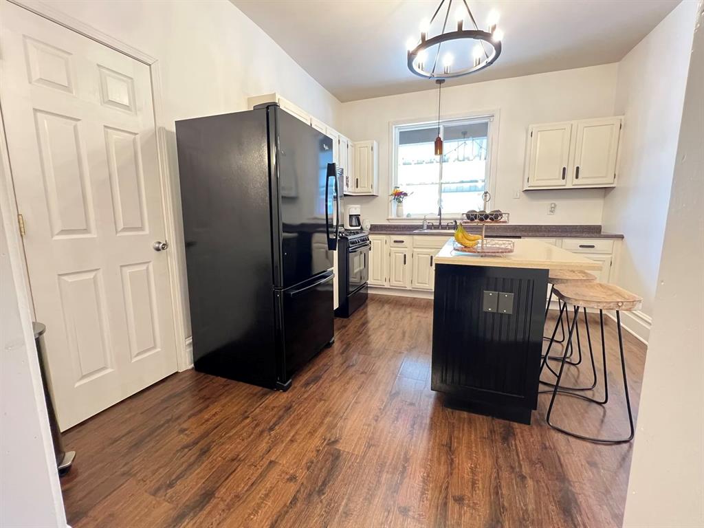 237 Lelia Street Pittsburgh, PA 15211 - Photo 10 of 46 a kitchen with stainless steel appliances granite countertop a refrigerator a sink dishwasher a stove and white countertops with wooden floor