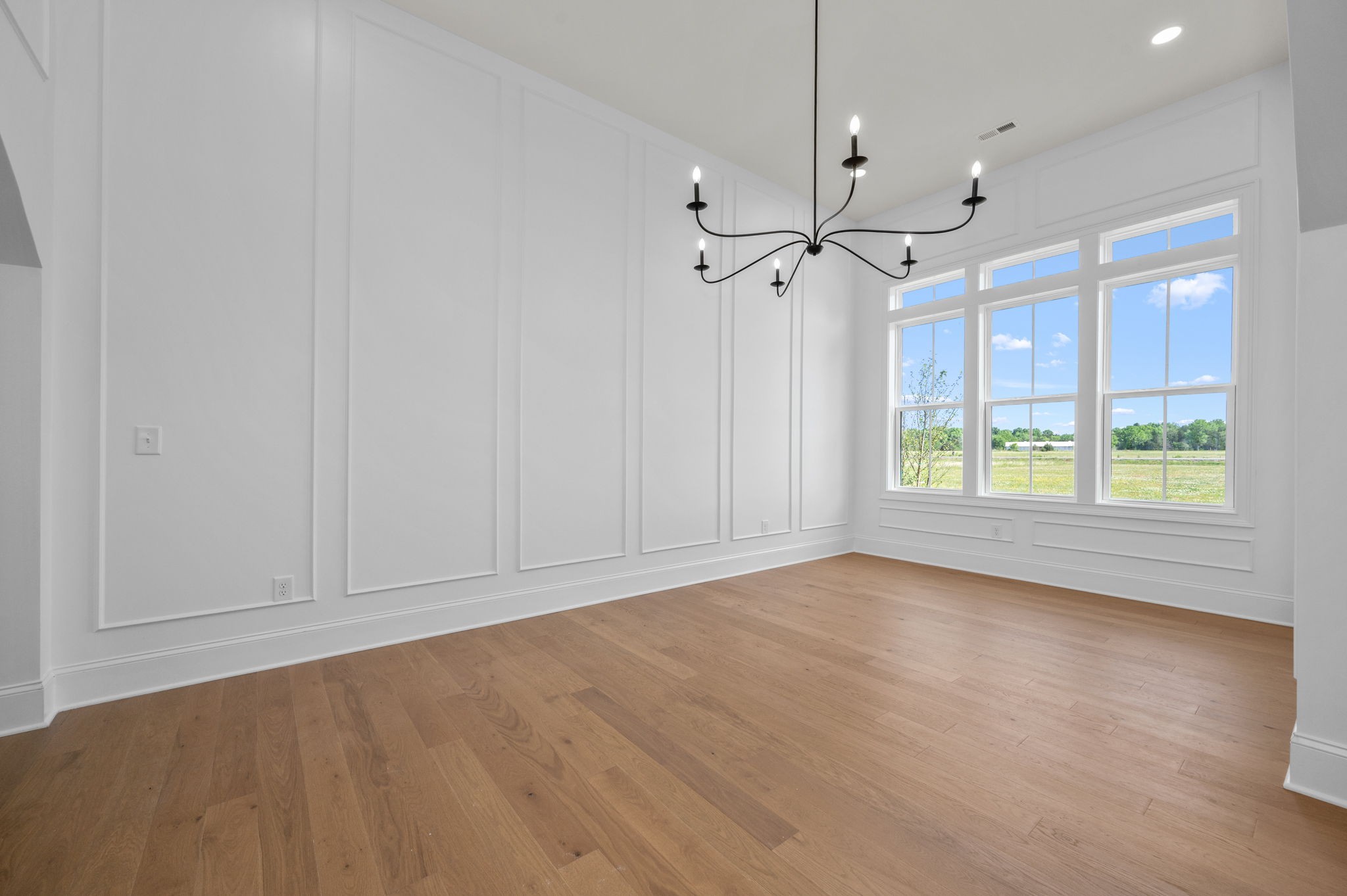 7838 Woodfin Road Christiana, TN 37037 - Photo 14 of 57 an empty room with wooden floor chandelier fan and windows