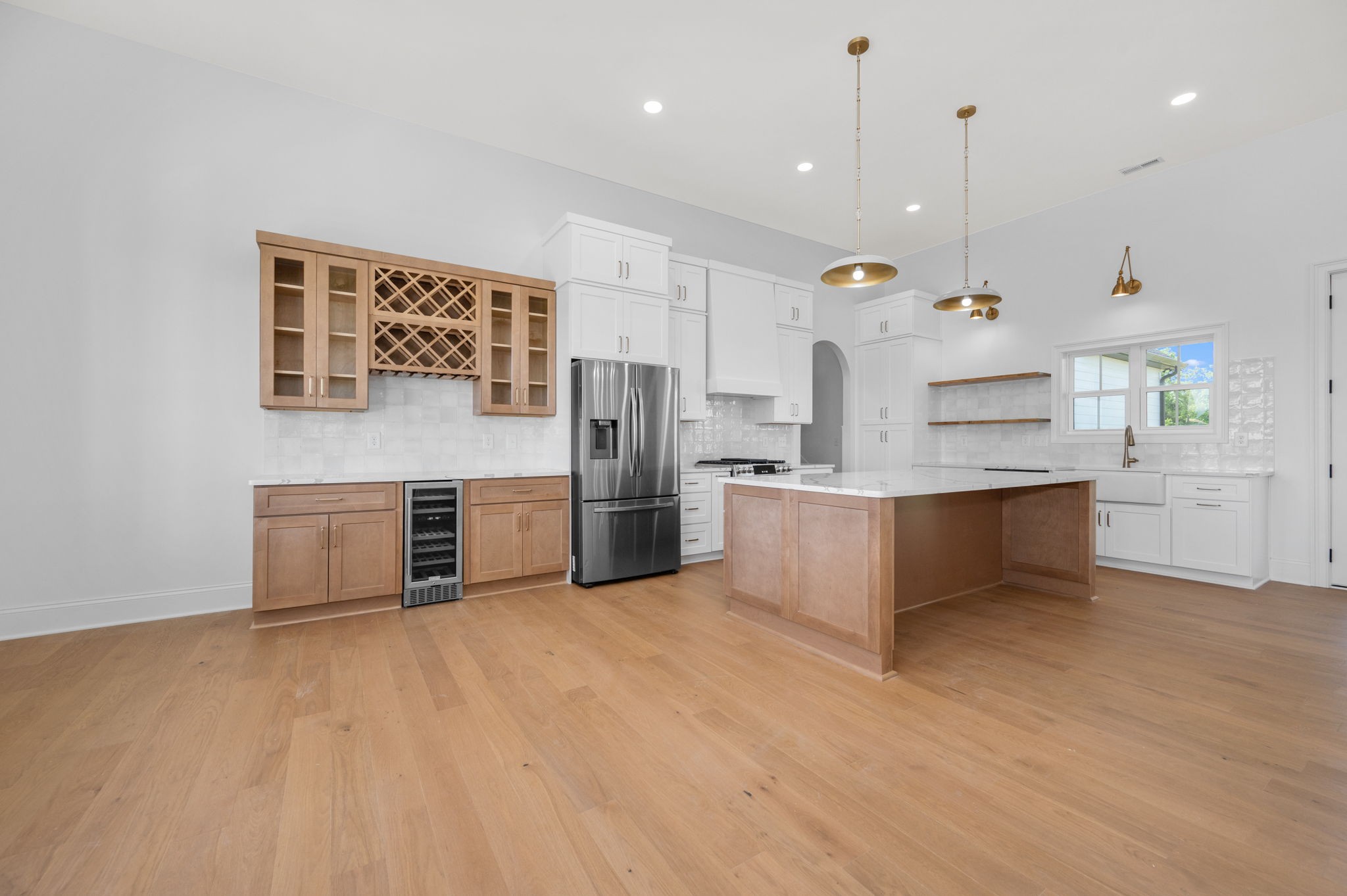 7838 Woodfin Road Christiana, TN 37037 - Photo 5 of 57 a large kitchen with stainless steel appliances a large counter top a stove a sink dishwasher and a refrigerator with wooden floor