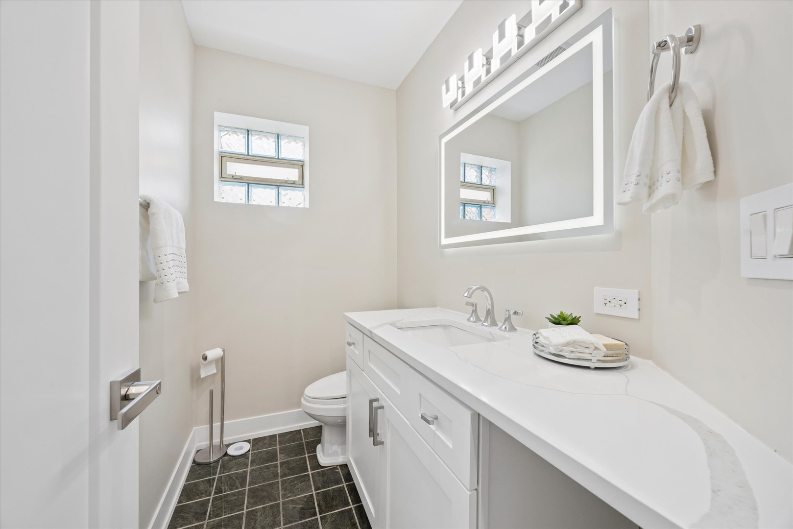 9807 West 57th Street Countryside, IL 60525 - Photo 17 of 48 a bathroom with a granite countertop sink a toilet and a mirror