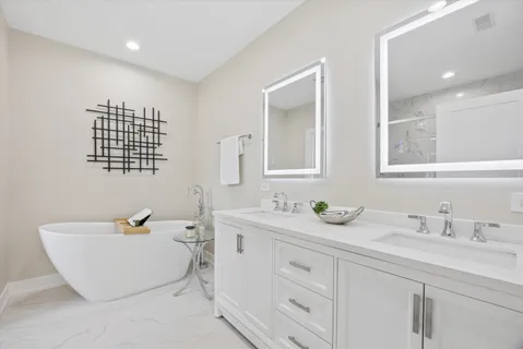a bathroom with a double vanity sink a mirror and a bathtub