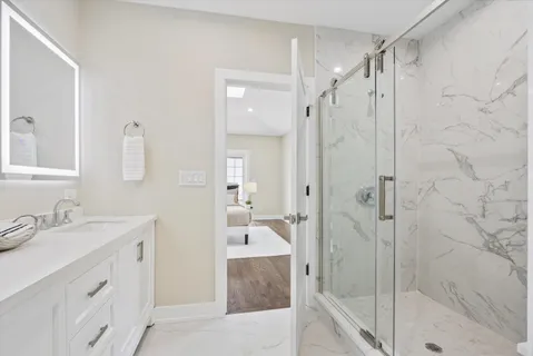 a bathroom with a granite countertop sink mirror and shower