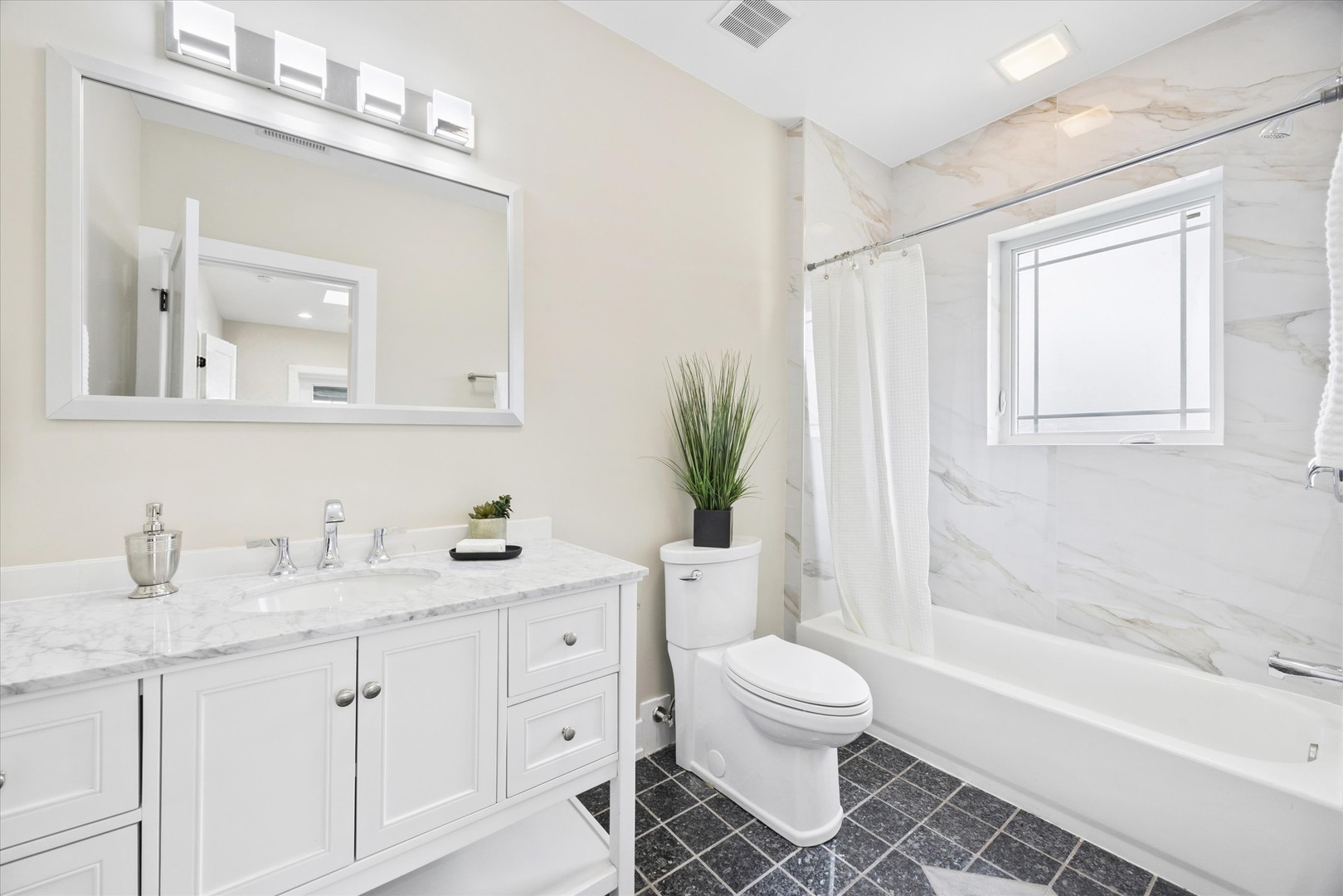 9807 West 57th Street Countryside, IL 60525 - Photo 29 of 48 a bathroom with a toilet a sink a tub and mirror