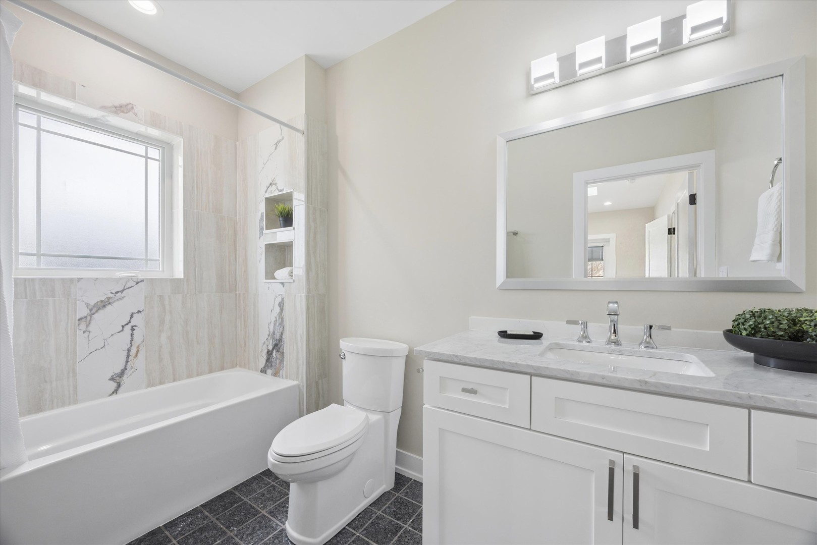 9807 West 57th Street Countryside, IL 60525 - Photo 32 of 48 a bathroom with a toilet a sink a mirror a bathtub and vanity