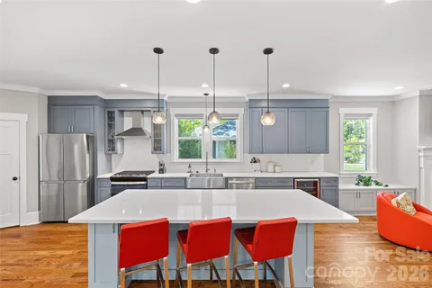 a kitchen with stainless steel appliances kitchen island granite countertop a kitchen island a stove a dining table and chairs