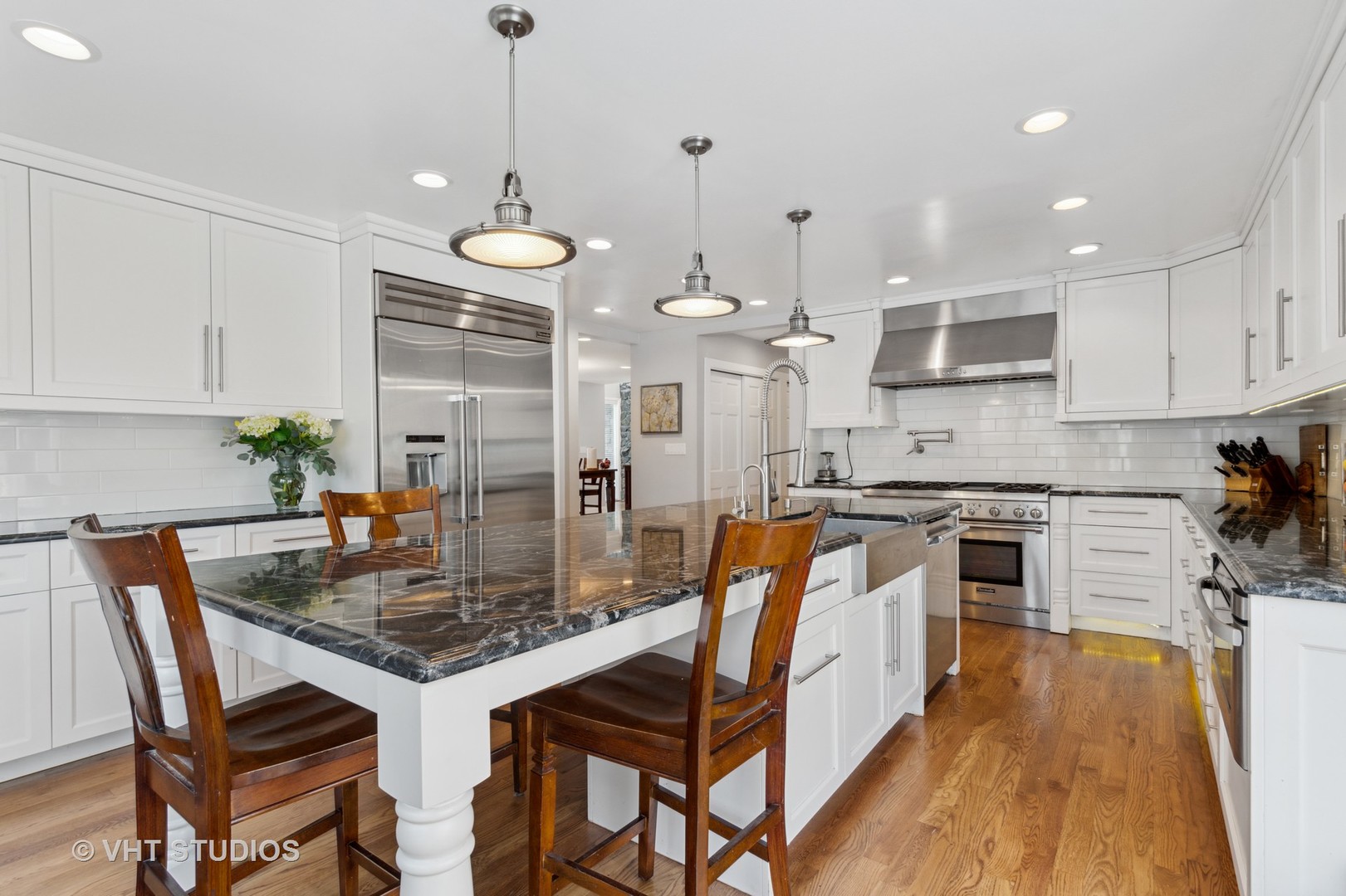 2079 Old Briar Road Highland Park, IL 60035 - Photo 14 of 20 a kitchen with stainless steel appliances granite countertop a stove top oven a refrigerator a sink and a dining table with wooden floor